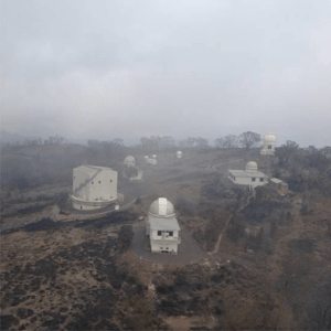 The square "dome" on the left houses the ANU's 2.3 metre telescope which stayed a comfortable 20 degrees throughout the fire. The dome to the top right is the new SkyMapper telescope, led by Nobel Laureate Brian Schmidt and built to continue the work of the Great Melbourne Telescope after it was destroyed in the Mt Stromlo fires. Temperatures there peaked at 65 °C. Source: Rural Fire Services